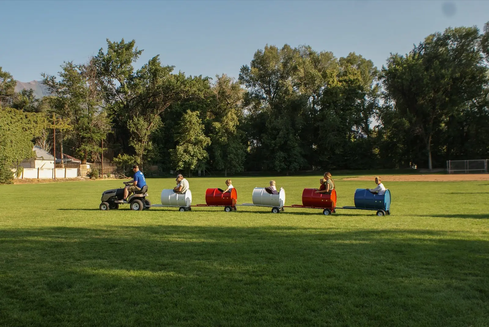 Kids riding the Backyard Barrel Express with mountains behind