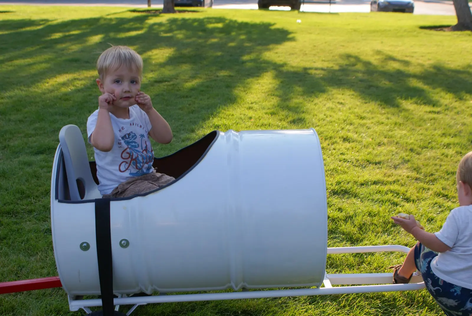 A child peeking out of a barrel car